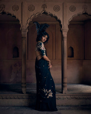 Model is posing to show the side of the floral blouse and pre-draped saree