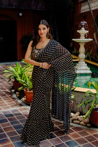 Featuring a black floral booti printed pre-draped saree in georgette base with sequins and gota work border. It is paired with a waist belt and a sleeveless blouse, both based in black silk with hand embroidered florals.