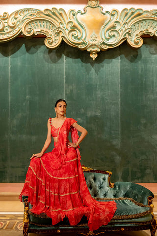 A cherry red monotone printed pre–stitched saree, paired with a heavily hand highlighted blouse with tassel detailing on the straps. Designed by Paulmi and Harsh