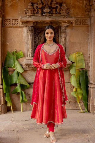 Featuring a cherry red anarkali in zari tissue base with scallop embroidered cutwork neckline paired with a matching lycra churidaar payjama. It comes with a cherry red foil printed dupatta in organza base with gota lace edging on all sides.