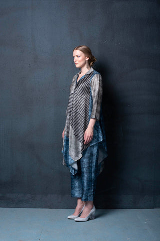 A two piece dupion silk set comprised of geometrical abstract print, asymmetrical hemline and parallel pants with fusion textile play of abstract print. Designed by clos.