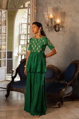 Pnh Emerald Green chiniya silk peplum set paired with cotton silk base palazzo with antique tone gold sequins and zari embroidery a perfect look for mehndi, sangeet ceremony or festivities