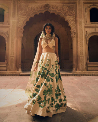 A close up look of green floral print on lehenga, featuring intricate hand-embroidery in aari, zardozi and sequins.