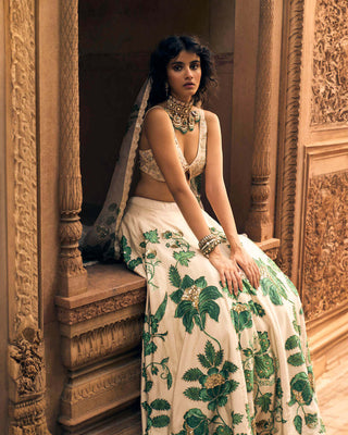 A close up look of green floral print on lehenga, featuring intricate hand-embroidery in aari, zardozi and sequins. And a blouse of cut printed and hand-embroidered blouse in floral inspired motifs.