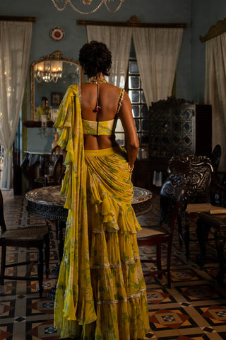 Model posing to show the back of the blouse and saree drap with fine crease with frill on dupatta.