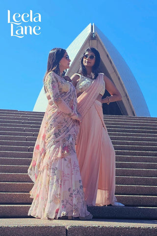 Two woman posing in Paulmi and Harsh Saree set.They are looking bold, chic, and unapologetically stylish. Perfect Festive Forward Glam look.