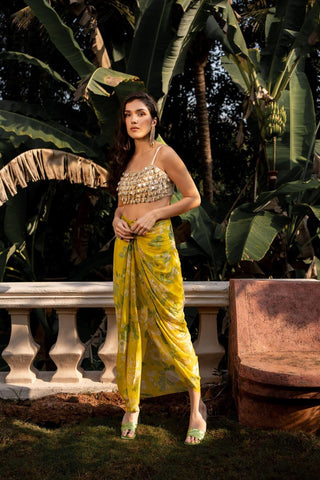 Model showcasing one strip blouse crop top featuring dainty ivory and yellow floral print with kaudi shells and coin detailing and it has been hand tucked.