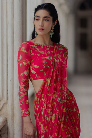 A floral printed pre–stitched saree in the shade of peony pink, a great option for a roka ceremony, wedding, festival, Diwali, Indian Ceremonies. Designed by Paulmi and Harsh. 