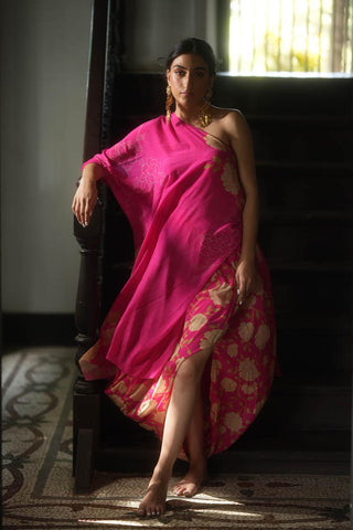 A rani pink gorgeous rose print draped one shoulder tie up dress, paired with an all–over printed cowl skirt designed by Paulmi and Harsh. A dress perfect for casual parties, beach wear, holidays, coastal day trip, girls party.