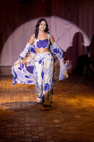 Model facing the camera in a coordinated blue and white crop top and flared pants set with floral printed jacket, featured on the Australian fashion Grandeur runway. 