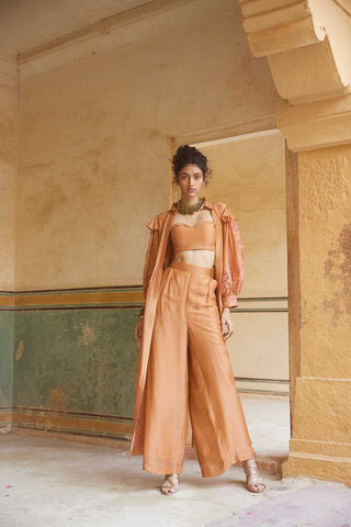 Designed by Paulmi and Harsh the peachy orange jacket set crafted in pure silk organza fabric and has a cutwork embroidery details as a design element. The jacket set has volumious sleeve details. The set includes bustier and straight fit trouser.  An Indo-Western women clothing a beach wear, party, summer wear, dinner date, evening dress to flaunt and style.
