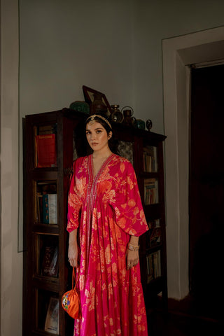 Floral jaal print kaftan set is crafted beautiful in hues of pink and oranges, featuring V-neck, patch border, drop sleeves, front slit and elastic gathers to accentuate the waist. The border is hand embroidered using mirror, resham, sequins, nakshi and cutdana. It is paired with straight cut printed pencil pants.