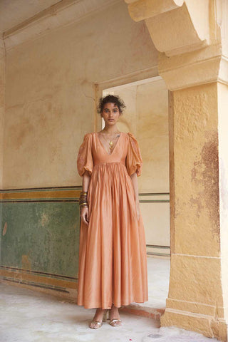 The peachy orange maxi dress crafted in a soft silk organza fabric. The dress has deep V neck with fully voluminous sleeves. The dress also features floral motif cutwork embroidery which makes it the perfect dress for a fancy brunch date.