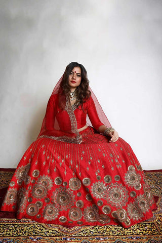 Red chakra lehenga designer wedding bridal attire for wedding pheras or engagement ceremony.