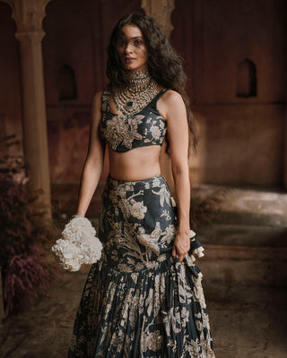 A romantic fish cut lehenga in our signature Roop flip bird print, featuring a pair of birds in their enchanting habitat. Hand–embroidered in mixed techniques, the print truly sings.It is paired with a U cut sleeveless blouse, featuring ornate hand-embroidery and an organza dupatta with scallops and delicate buttis.